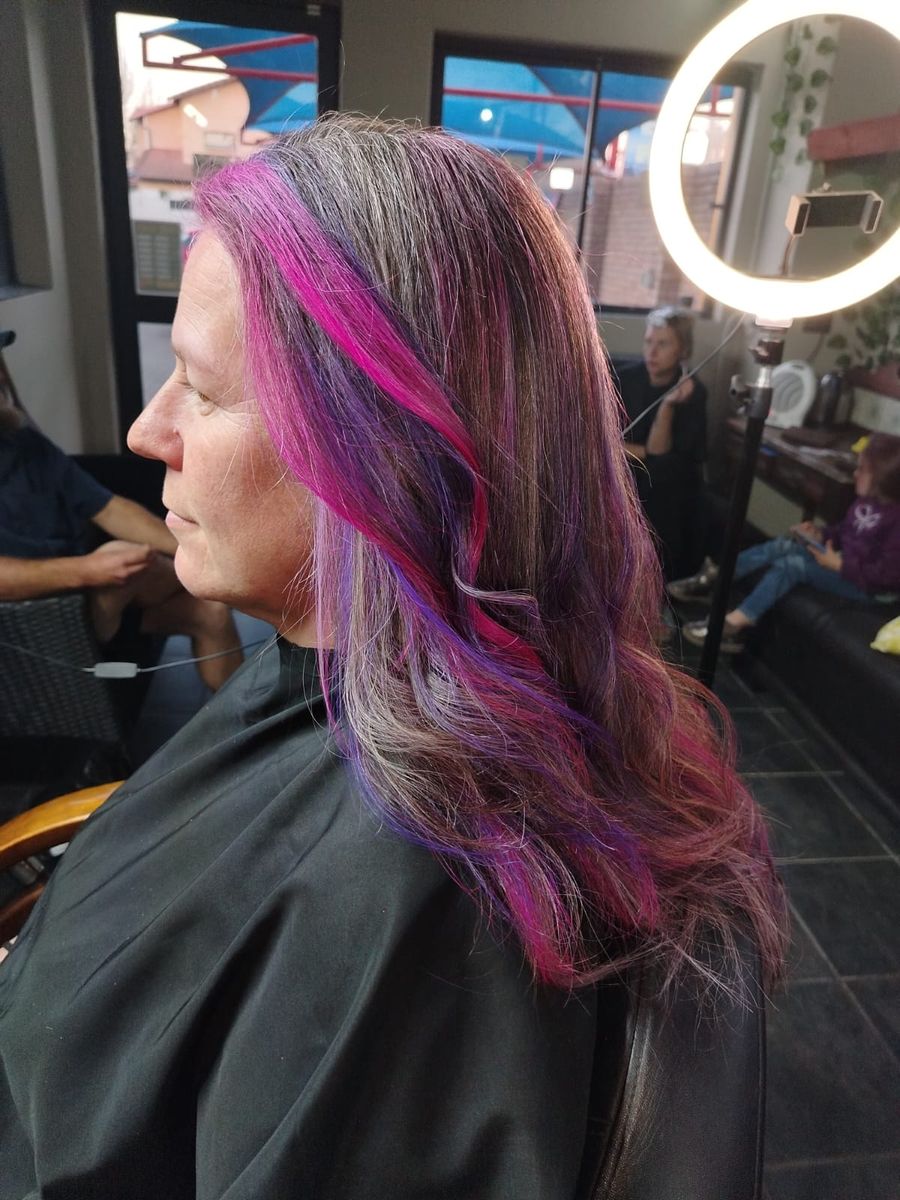 Pink and purple highlights woven through silver hair